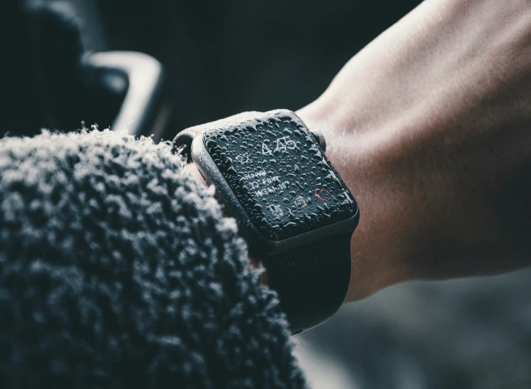 an apple watch with a black background and a gray wristband