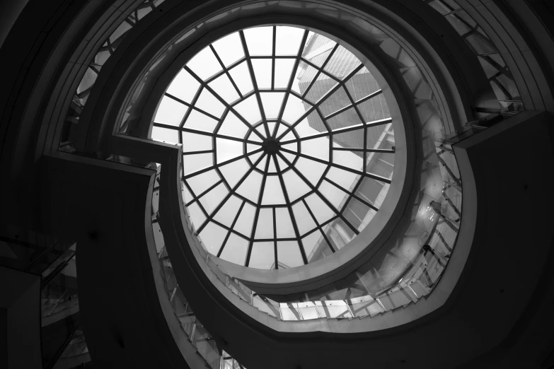 a circular roof made from glass sits in a building