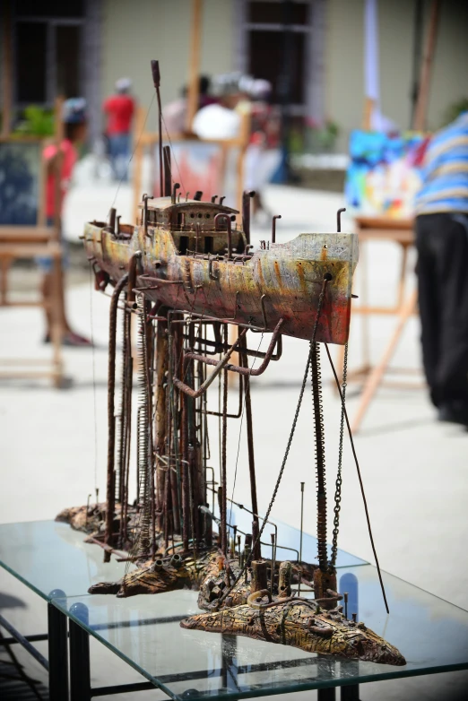 an image of an odd model of a building with pieces of rusty metal in the foreground