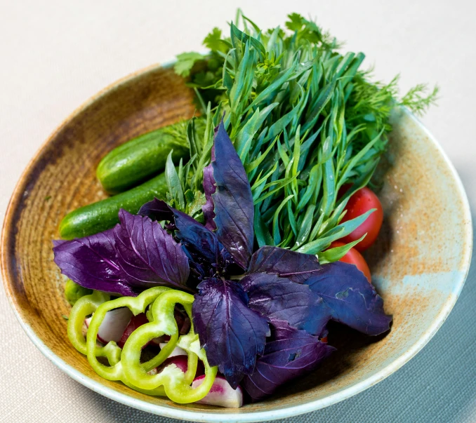 green and red salad sitting on top of a yellow bowl