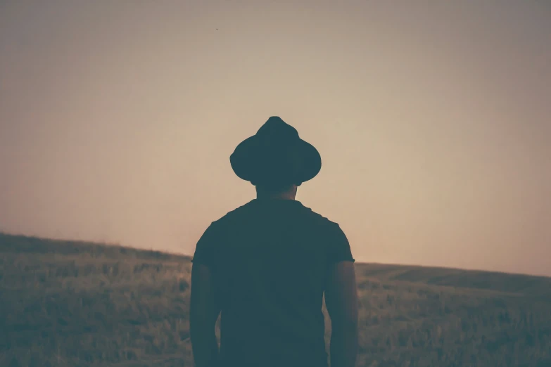 a man with a hat walking down the road