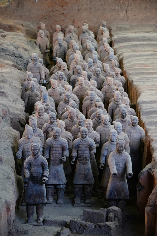 many statue statues are stacked together on the ground
