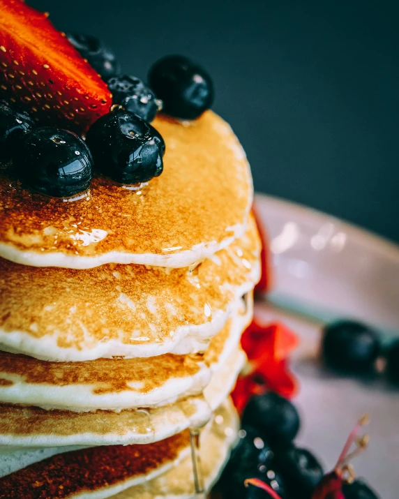 a stack of pancakes with strawberries and blueberries