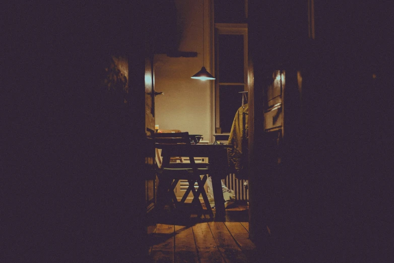 the hallway way shows a dark room and two tables