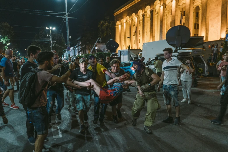 group of people standing around in the middle of a street