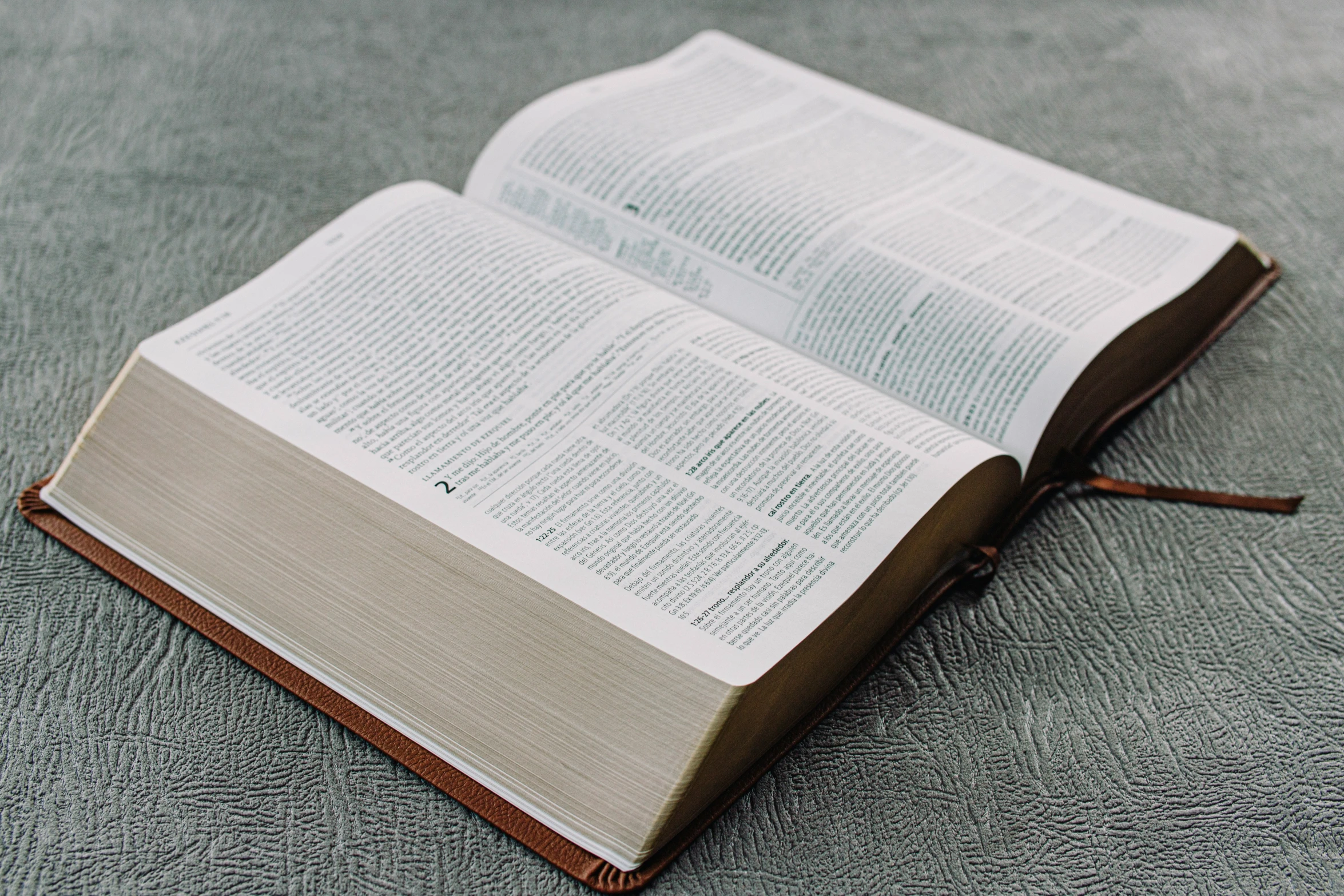 an open book sitting on top of a gray carpet