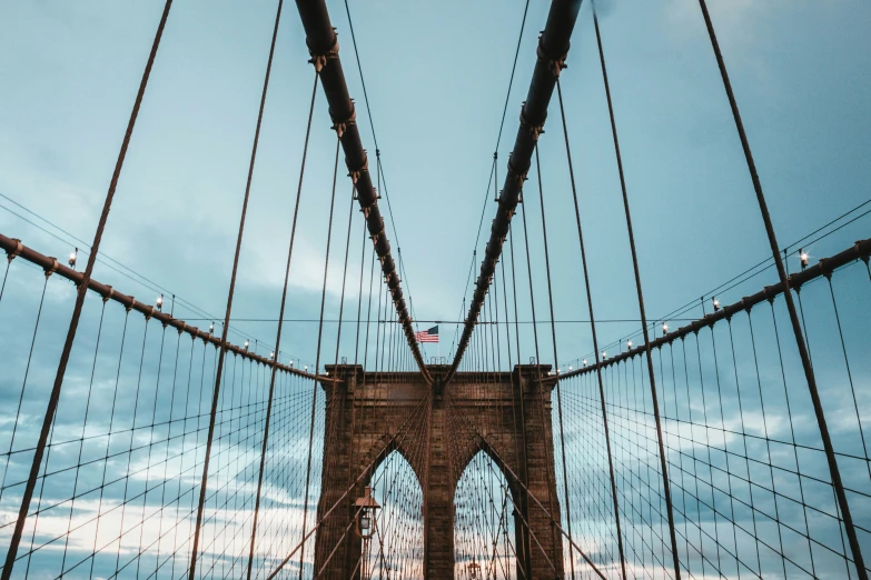 the view from underneath a bridge with wires on top