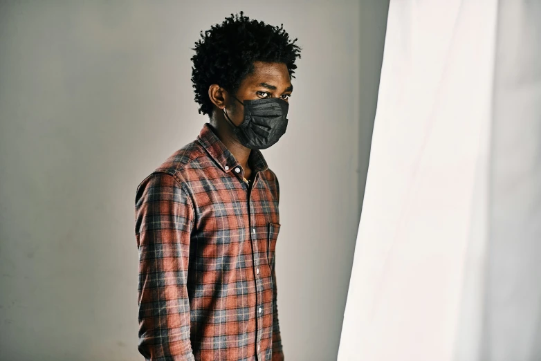 a man with an unoned shirt and a black face mask