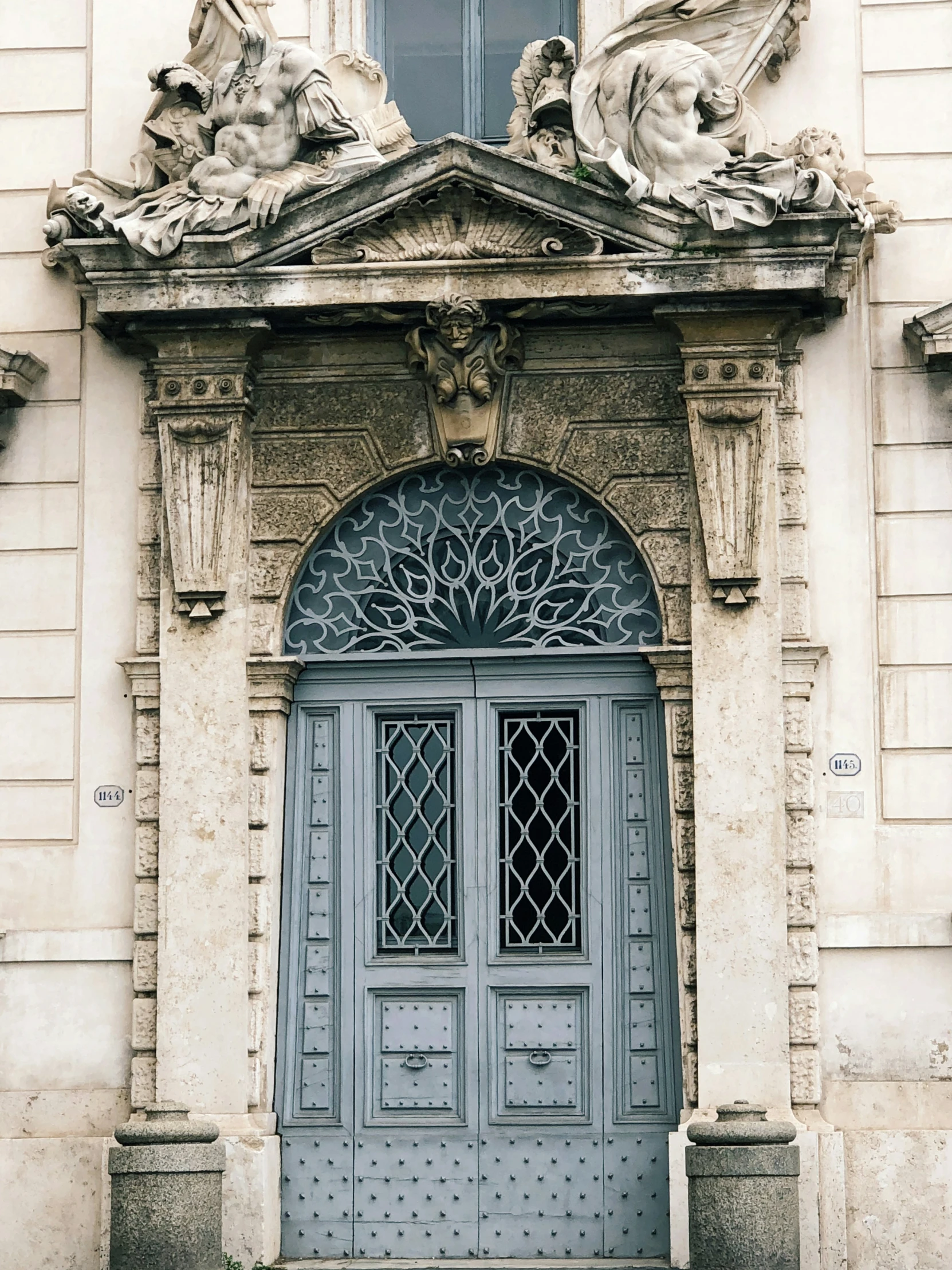 a very old door with sculptures on top