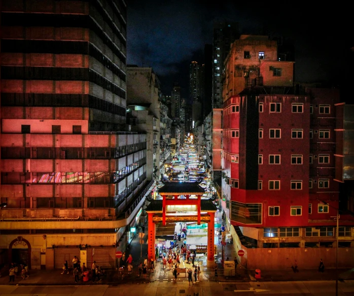 a street view at night, with the lights turned on and a person walking by