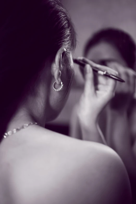 woman doing makeup on her neck with an instrument in front of her