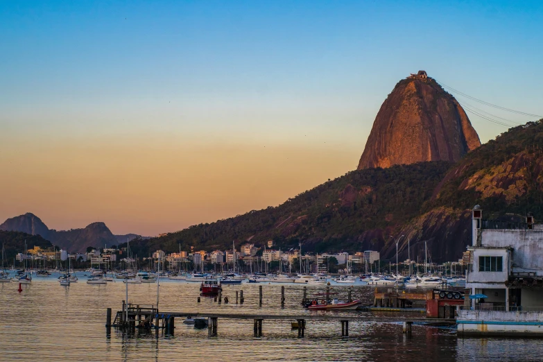 boats sit at dock during sunrise by mountain