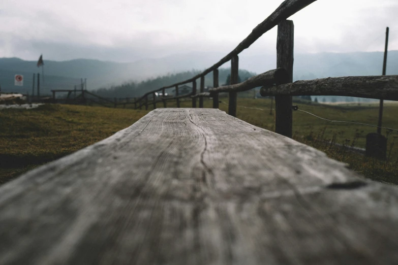 the long plank sits in front of a fence