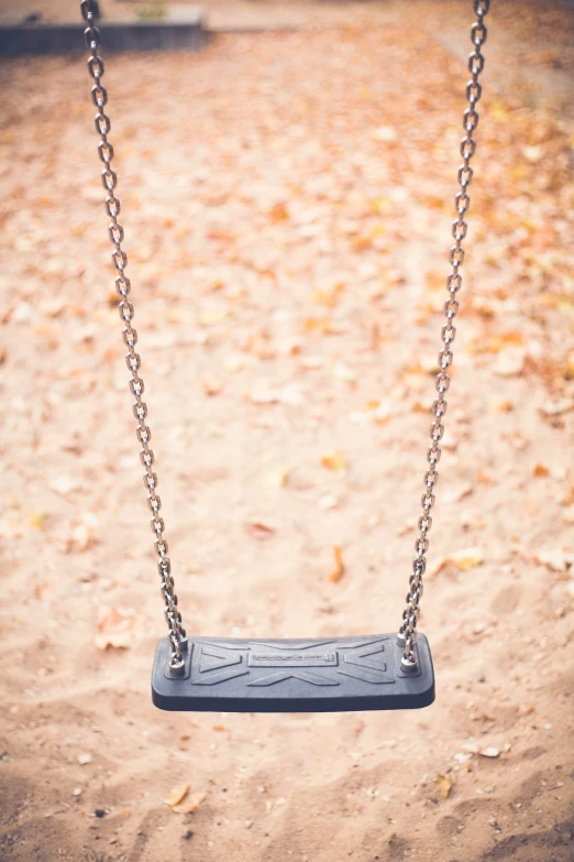 a blue swing suspended in the middle of a field