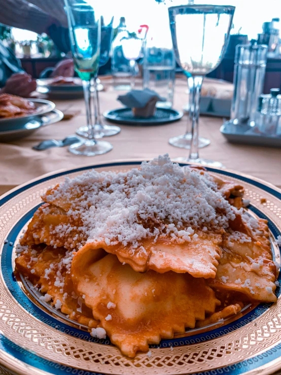 a plate topped with pasta and cheese covered ravioli