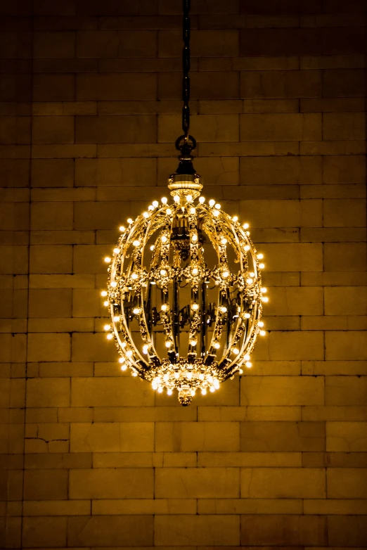 a lighted ball hanging from a long metal rope