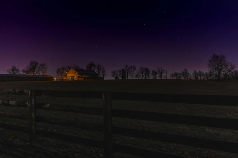 there is a barn at night on the grass