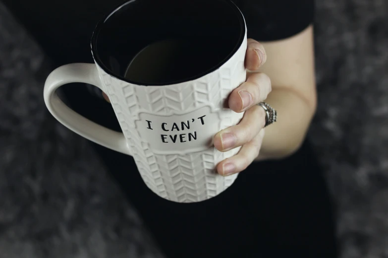 a person holding a coffee cup with writing on it