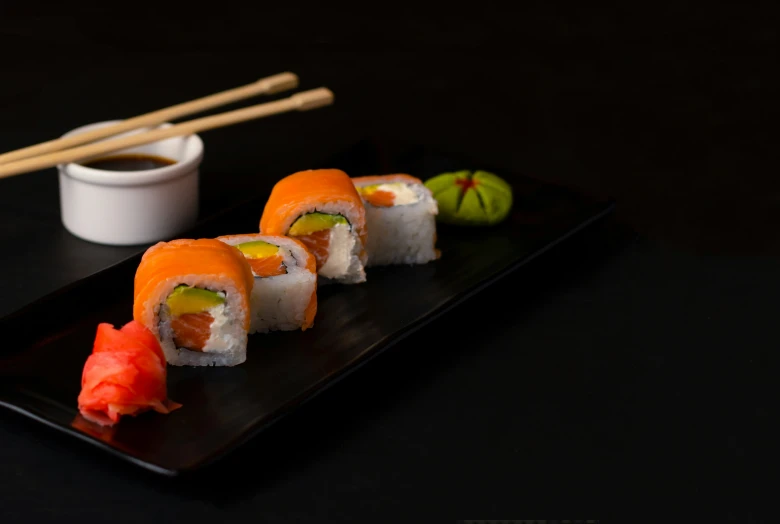 a plate of food with sushi and chopsticks on it