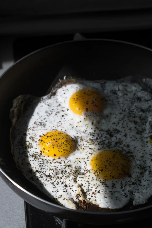 fried eggs in a frying pan on the stove