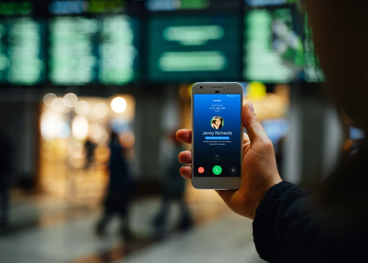 a person holding up a phone in front of an electronic display