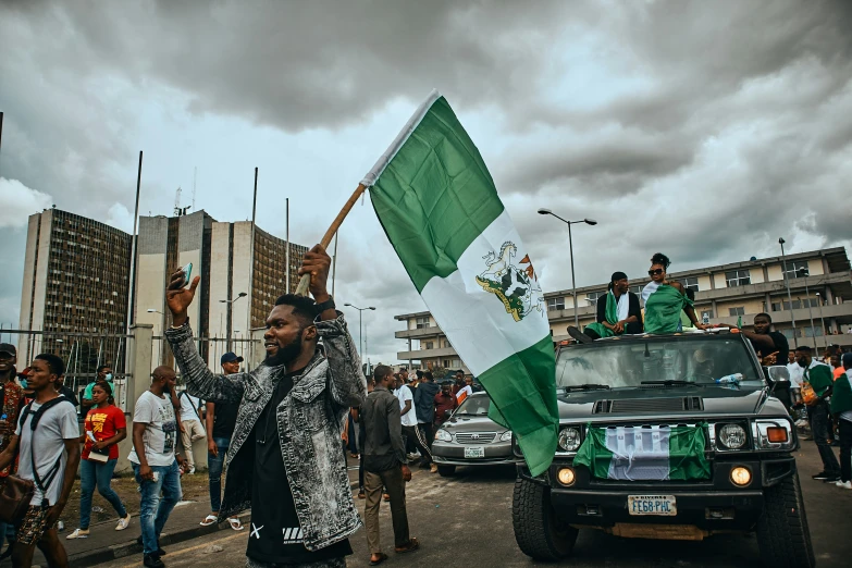 a man with a flag in his hand and a jeep on the side