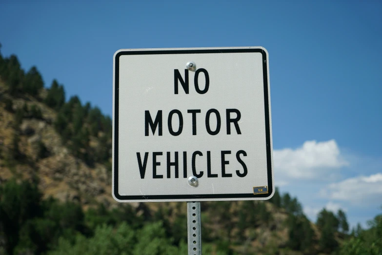 a sign saying no motor vehicles is hanging on a pole
