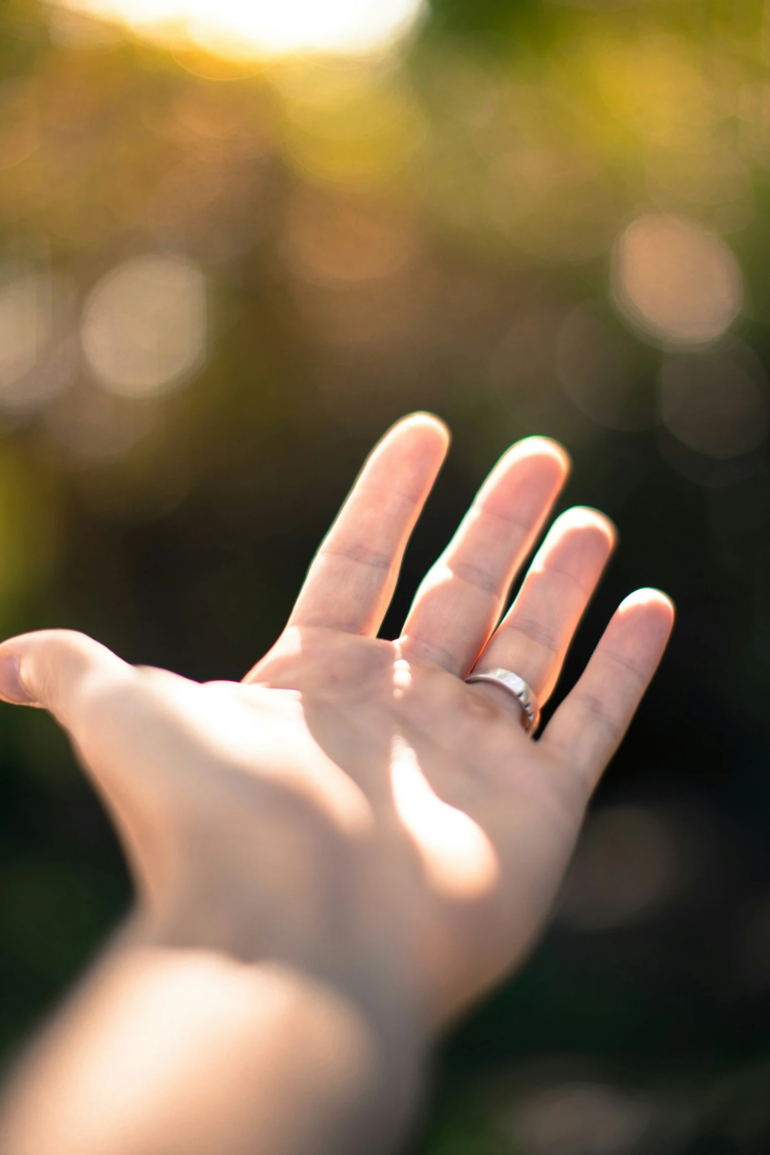 a person's hand and a ring sitting on the palm of their outstretched hand