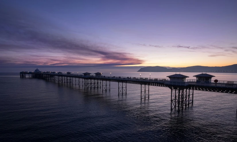 pier with two sets of wooden posts sitting on top of the water