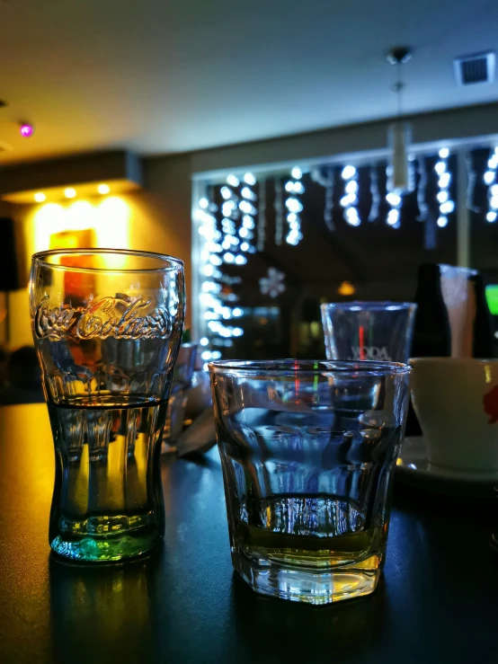 two s glasses sit next to each other on a bar