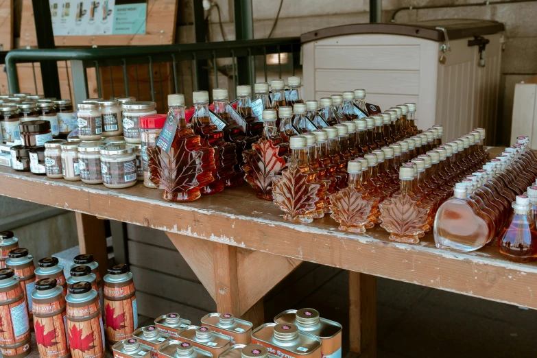 various types of bottles and jars on a wooden bench