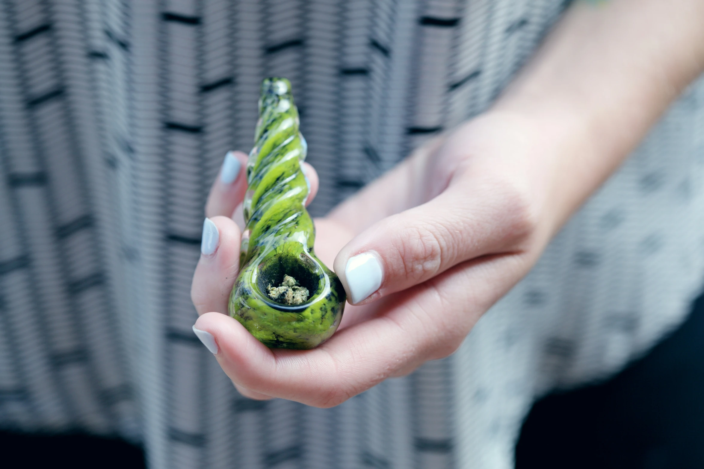 a woman holding a green ceramic sculpture in her hands