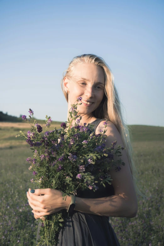 a woman holding some flowers on her shoulder