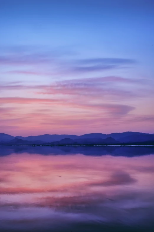 the setting sun is lit up over a large body of water