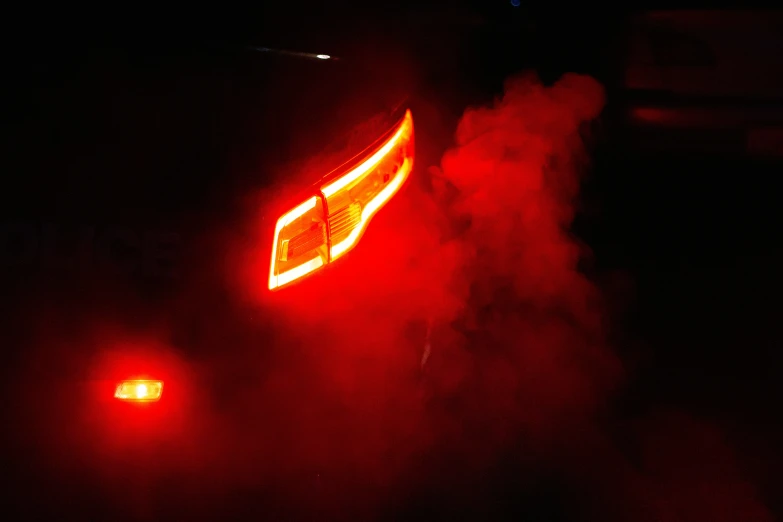 a red tail light reflecting off the side of a vehicle