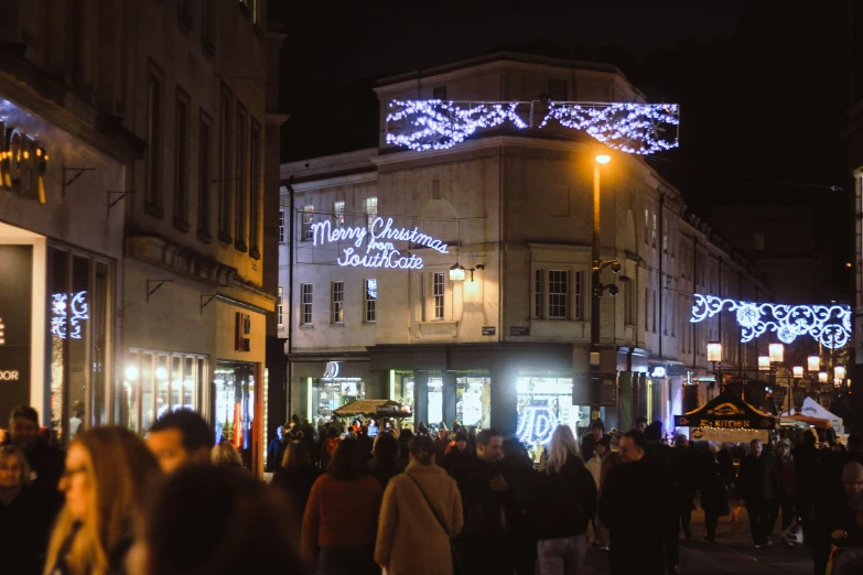 a busy city street with people walking along it at night