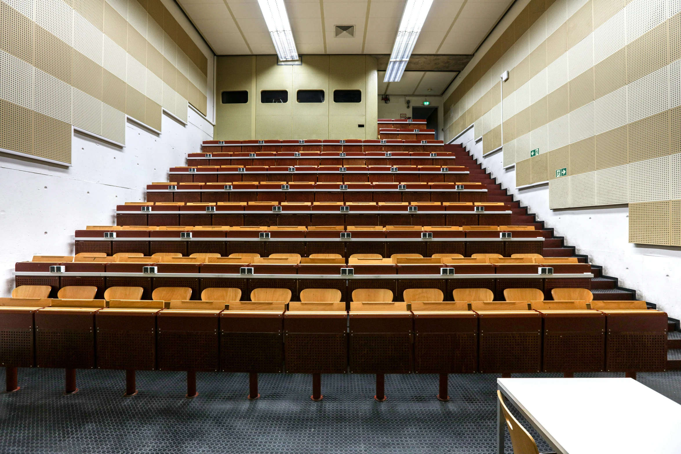 an empty lecture hall filled with chairs and tables