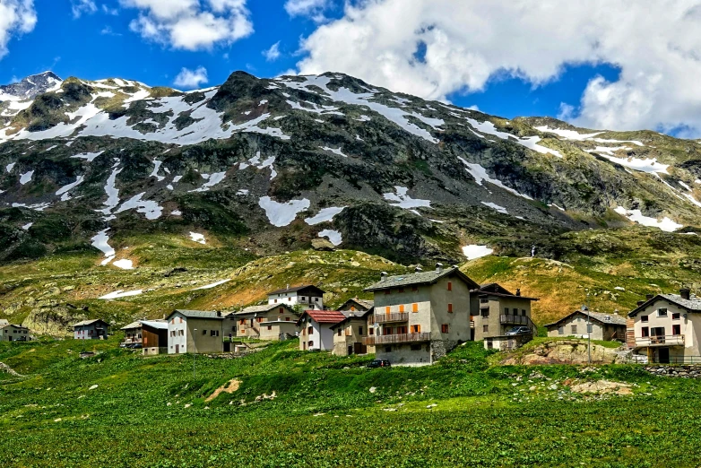 green mountains surrounding a city with several houses below