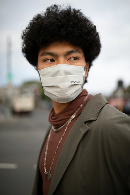 a man with black hair wearing a white mask