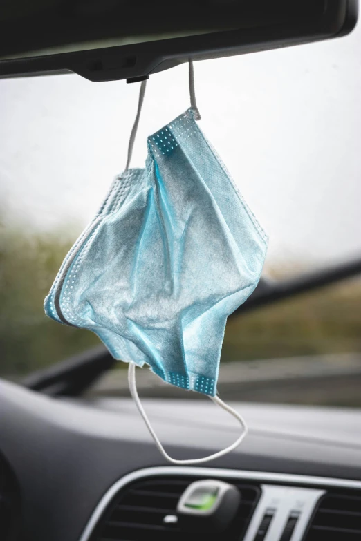 a cloth pouch hanging on the dashboard of a car