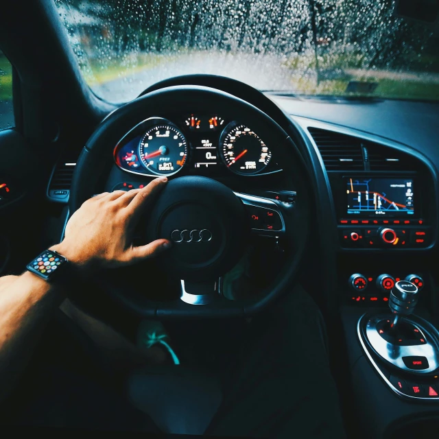 person sitting in a car while holding a steering wheel