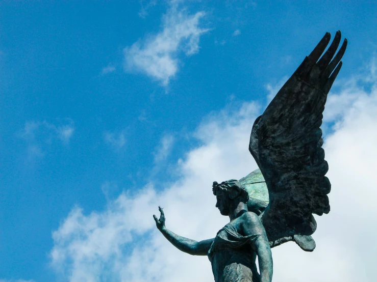 a statue of a person holding an animal, with a sky background