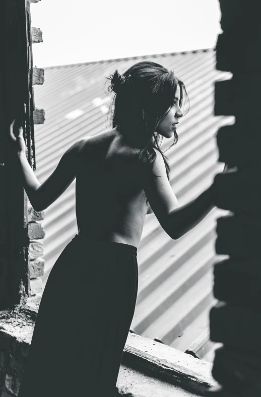 a woman wearing a dress standing near a brick wall