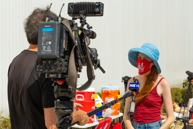 a woman with a red face painted on next to a camera