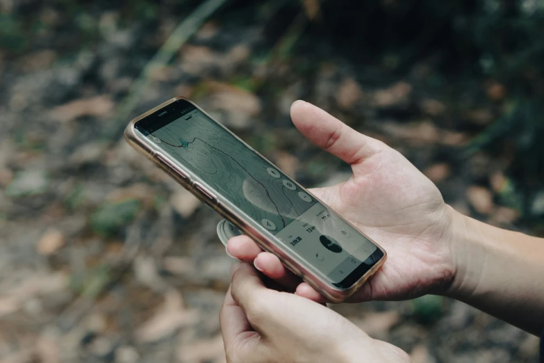 someone is holding an apple iphone with the screen broken off