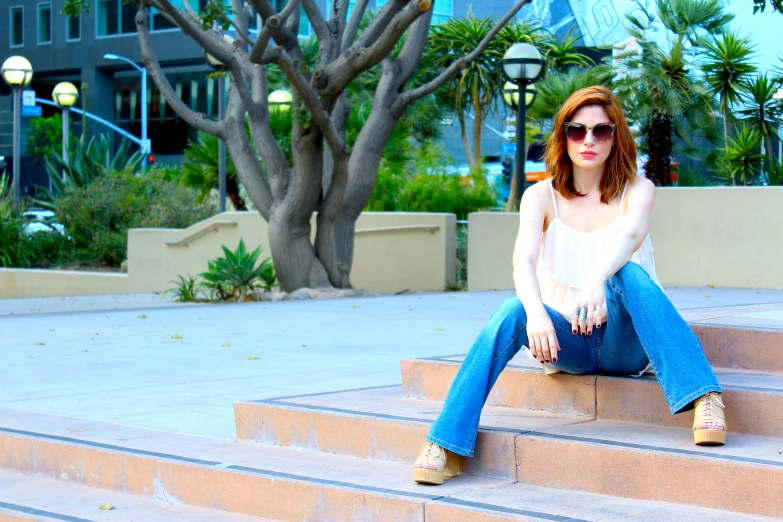 a young woman is sitting on the steps of stairs