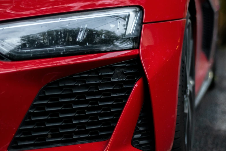 the side of a red sports car's grille