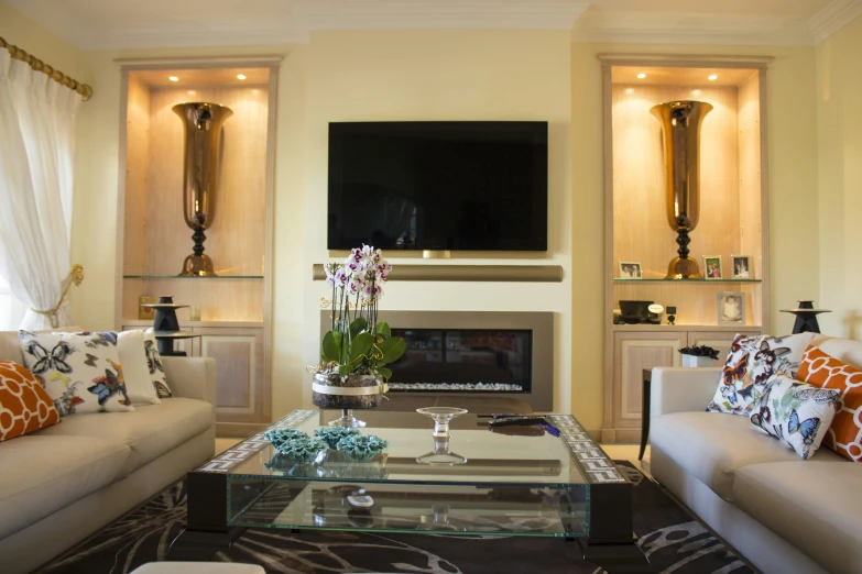 a nice room with beige colored sofas, pillows and a fireplace