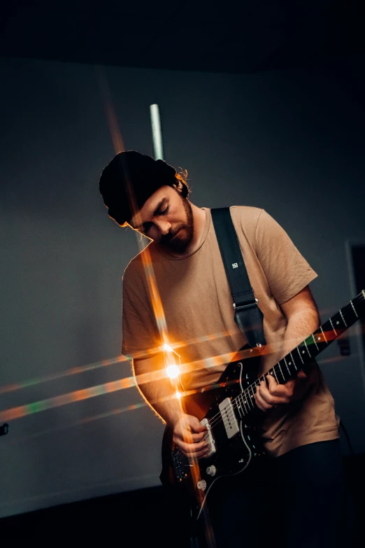 a person playing with a guitar with a light from its spot