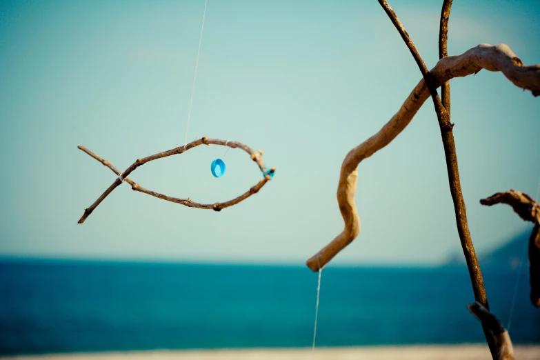 a tree with nches and some blue beads hanging from it